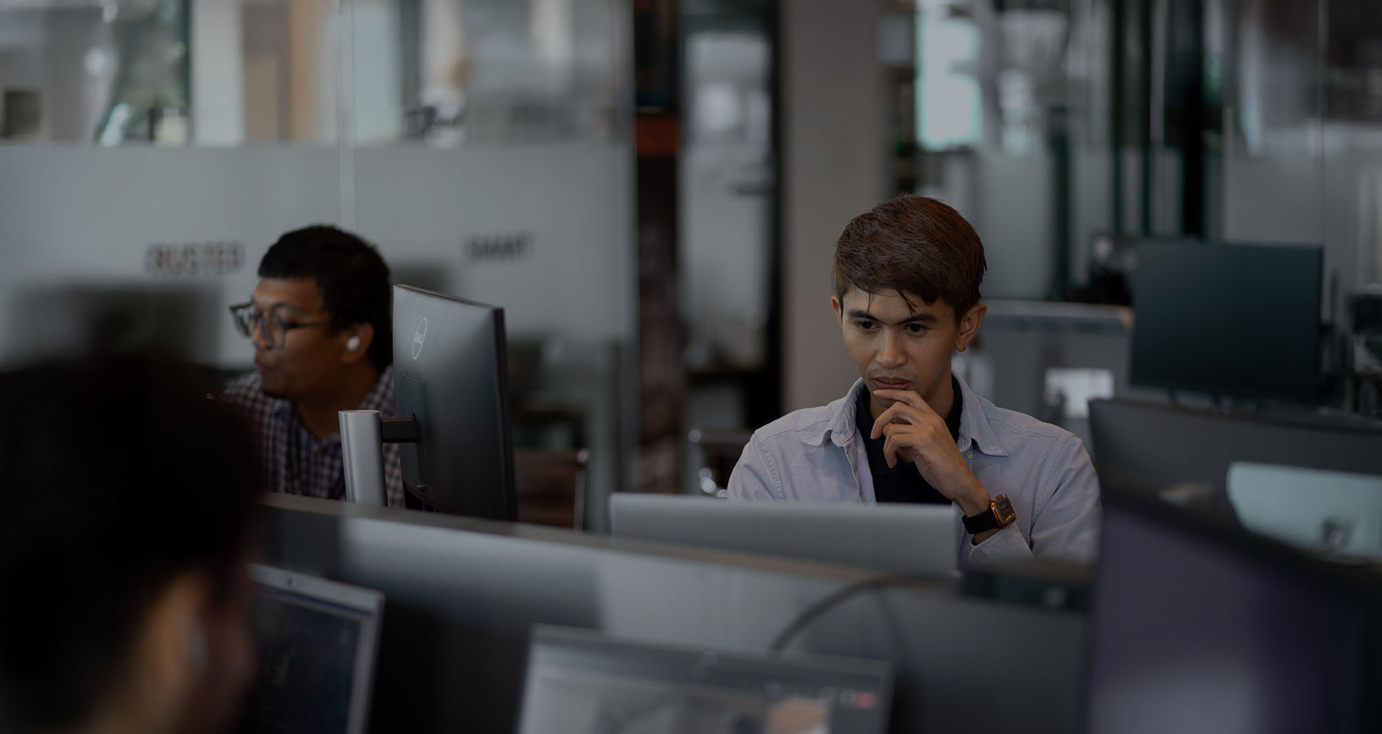 Man in open office looking at computer screen